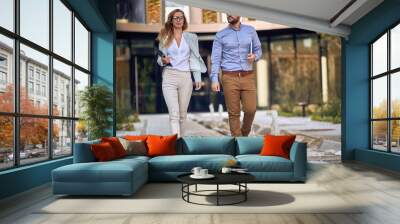 Casual business male and female colleagues going outiside Wall mural