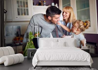 Child with parents having fun during breakfast Wall mural