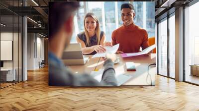 Close-up of young colleagues in a commission having a pleasant talk with a young male applicant during an interview for a job. Business, people, company Wall mural