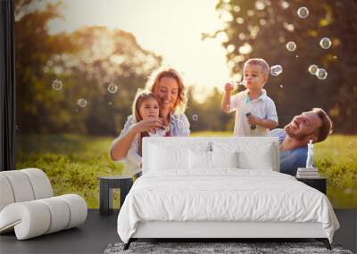 Family with children blow soap bubbles outdoor Wall mural