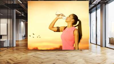 Female jogger drinking water Wall mural