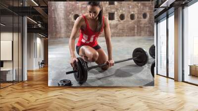 fitness woman preparing to lift some heavy weights. Wall mural