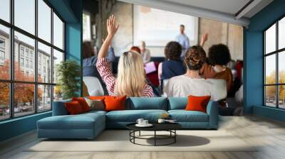 Group of young creative people are rising hands for a questions at a presentation in the office Wall mural