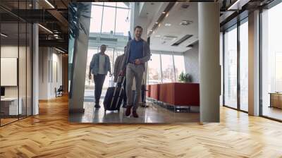 group of young men in the lobby of a hotel, smiling, walking, caring luggage Wall mural