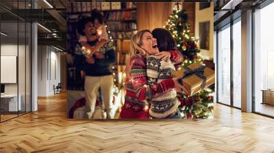 Happy holiday - girlfriends celebrating Christmas together. Wall mural