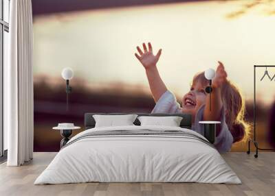 Happy kid looking at the sky . fun on countryside, sunset golden hour. Freedom nature concept. Wall mural