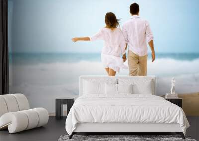 happy romantic young couple walking at the beach Wall mural