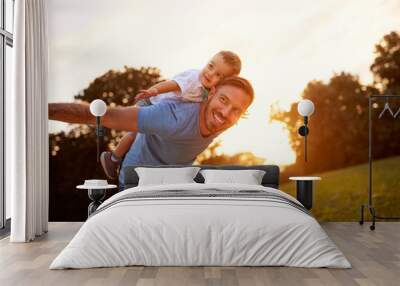 Happy young father with son in park Wall mural