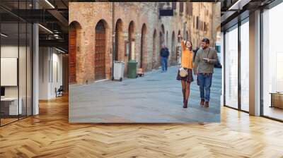 Smiling man and woman travelling in European Wall mural