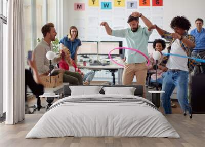 Two male employees is playing with hula-hoop in the office with their colleagues. Employees, job, office Wall mural