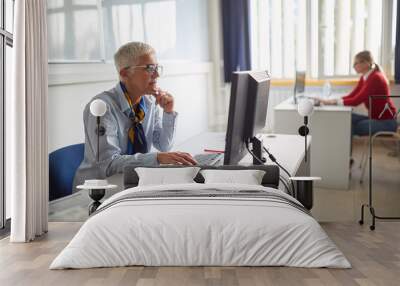 Woman in aged working in computer Wall mural