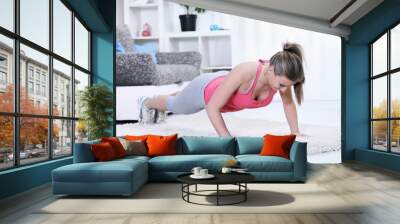 woman looking down while doing push-ups Wall mural