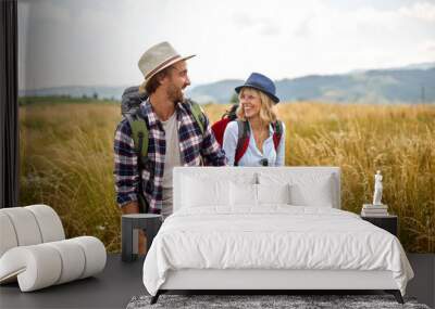 young couple hiking in countryside. happy people travelling in nature Wall mural