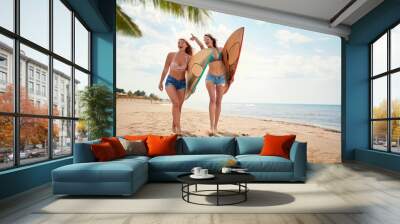 Young sexy female surfers excited on the beach Wall mural