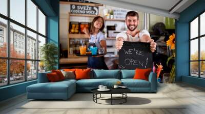 Young woman is serving the drinks and man is holding a sign Wall mural