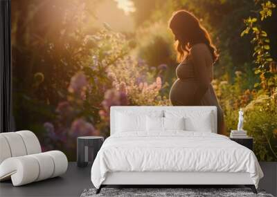 Beautiful pregnant woman in a garden at sunset, surrounded by colorful flowers and bathed in warm golden sunlight. Wall mural