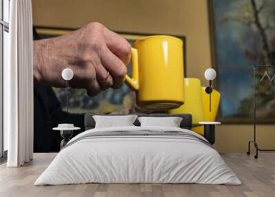 old man hands with three yellow mugs. Wall mural