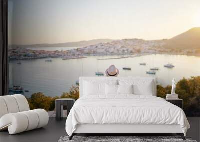 Enjoying vacation in Greece. Young traveling woman enjoying sunset on sea view point. Wall mural