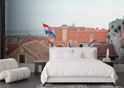 Enjoying vacation in Split. Young traveling woman with national croatian flag enjoying old town view. Wall mural