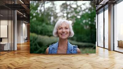 Portrait of happy elderly woman smiling and looking at camera outdoors. Wall mural