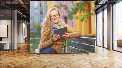 pretty young blond caucasian smiling woman using tablet computer Wall mural