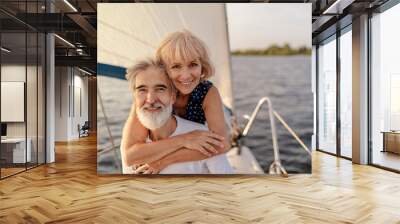 Romantic vacation and luxury travel. Senior loving couple sitting on the yacht deck. Sailing the sea. Wall mural