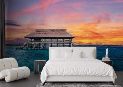 Wooden bungalow on piles in the sea. Wall mural