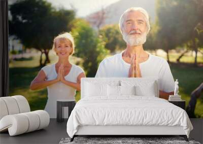 Yoga at park. Senior family couple  outdoors. Concept of calm and meditation. Wall mural