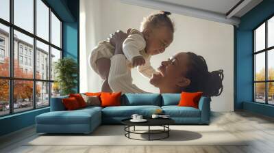 African mother with braided hair lifting her laughing baby in the air, both smiling, minimalistic background, bright indoor light Wall mural