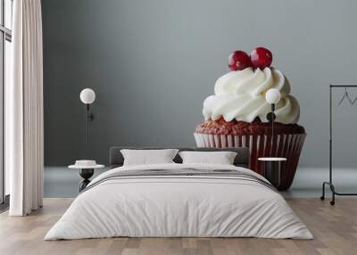 Cranberry spiced cupcake with smooth cream cheese frosting topped with two cranberries, set against a minimalist gray background Wall mural