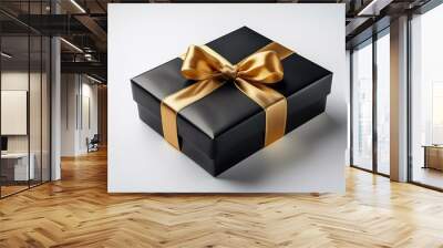 Elegant black gift box design featuring a golden bow and flowing ribbon on a bright white background Wall mural