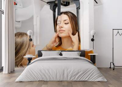 Female dentist and patient using X ray machine Wall mural