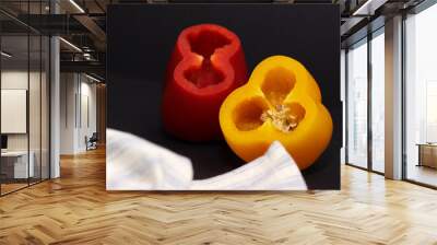 yellow, red and orange bell pepper dinner on black background with white blue striped napkin Wall mural