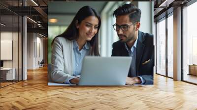 Indian financial advisors, both male and female, discuss a stock market strategy in a modern company using a laptop computer. Managers from South Asia Work Together on a Banking Project 
 Wall mural