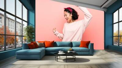 Asian young woman over isolated pink background celebrating a victory Wall mural