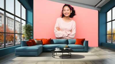 Asian young woman over isolated pink background keeping the arms crossed in frontal position Wall mural