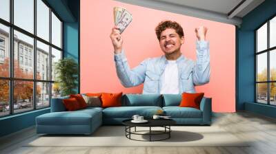 Blonde man over pink wall taking a lot of money Wall mural