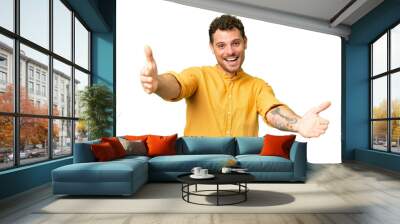 Brazilian man over isolated chroma key background presenting and inviting to come with hand Wall mural