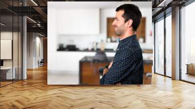 Brunette man looking lateral inside house Wall mural