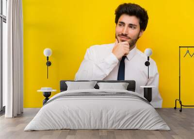 Businessman on isolated yellow background thinking an idea Wall mural