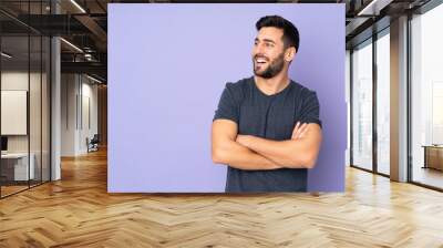 Caucasian handsome man happy and smiling over isolated purple background Wall mural