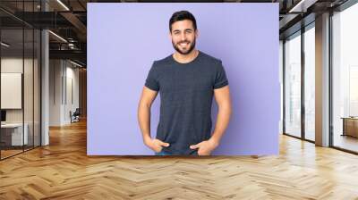 Caucasian handsome man laughing over isolated purple background Wall mural