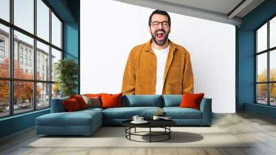 Caucasian handsome man with beard wearing a corduroy jacket over isolated white background shouting to the front with mouth wide open Wall mural