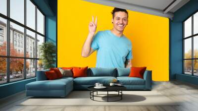 Caucasian man over isolated background smiling and showing victory sign Wall mural