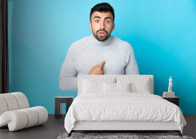 Caucasian man over isolated blue background pointing to oneself Wall mural