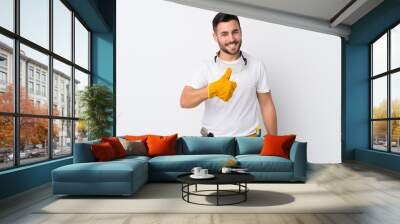 Craftsmen or electrician man over isolated white background giving a thumbs up gesture Wall mural