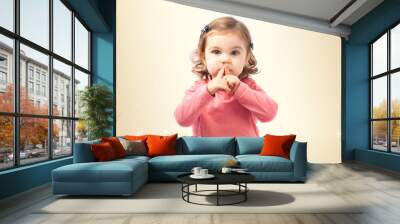 Cute girl doing silence gesture over white background Wall mural