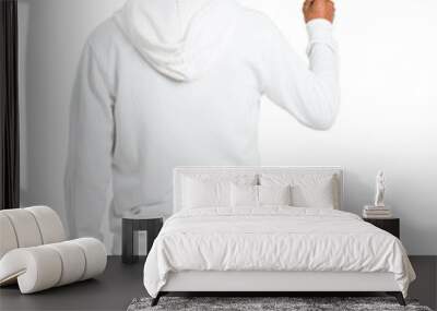 Dark-skinned young man with white sweatshirt pointing back with the index finger on isolated white background Wall mural