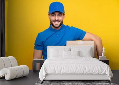 Delivery man over isolated yellow background smiling a lot Wall mural