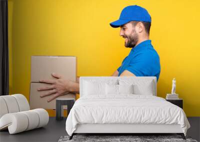 Delivery man over isolated yellow background with happy expression Wall mural